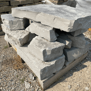 Stack of large, flat limestone slabs on a wooden pallet.