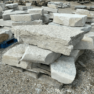 Stacked natural stone slabs at Whispering Hills Nursery for landscaping.
